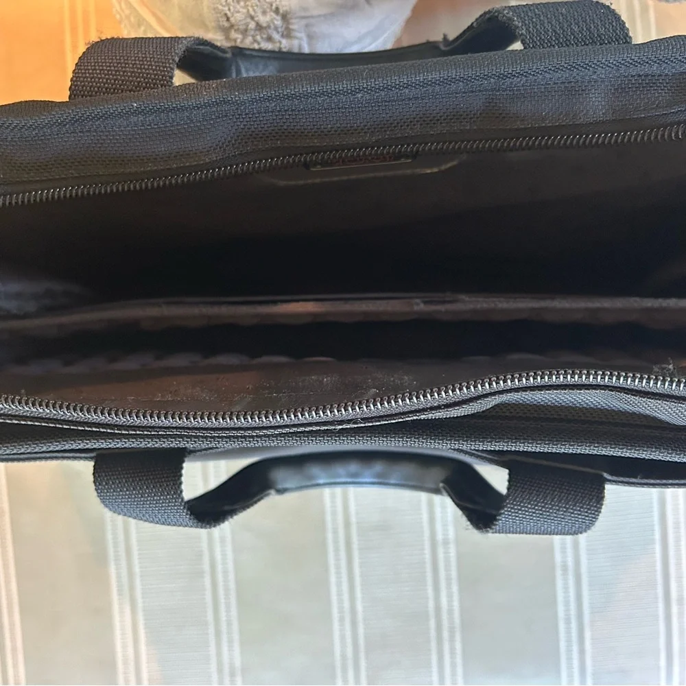 Tumi Black Briefcase with Adjustable Straps and Multiple Compartments